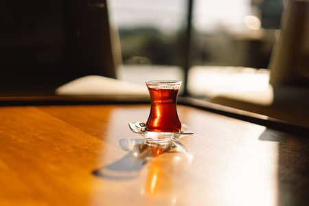 Turkish tea served in tulip-shaped glass on rustic table. Turkish tea in traditional glass cup.の写真素材