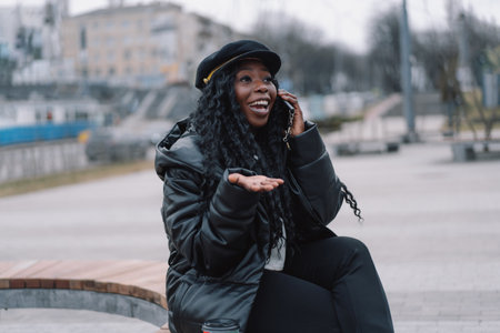 Afro girl uses the phone on the outdoors. People using technologyの写真素材