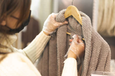 Young woman wearing face mask and protective gloves in store. Today people lifestyle conceptの写真素材