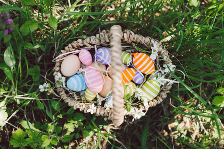 Basket with easter decorative eggs in the garden. Happy easter card.の写真素材