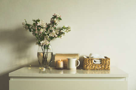 Book, candle and vase with apple spring flowers.