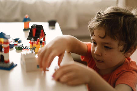 Cute boy is playing constructor at home. Kid playing block toys in home at nursery.の写真素材