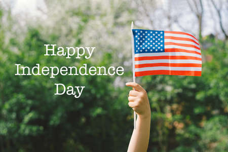 Happy little patriotic boy holding American flag.の写真素材