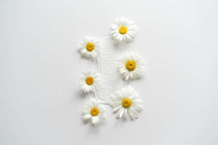 Menstruation period concept. Hygienic white female pad with chamomile flowers.の写真素材