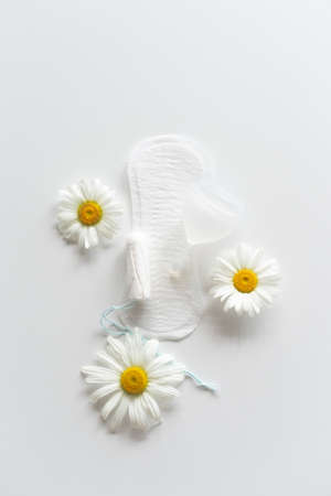 Hygienic white female pad, Menstrual cup and tampon with chamomile flowers.の写真素材