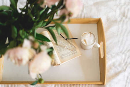 Open book and bouquet white pink peonies flowers. Read and rest. Cozy home