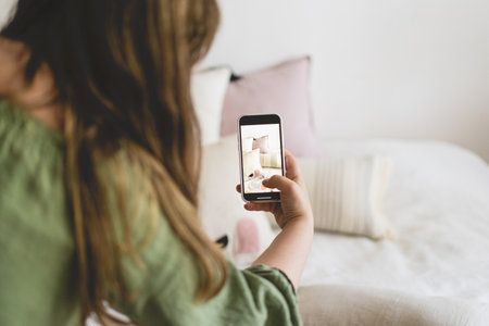 A young woman is filming home goods for her online store on her phone camera.