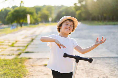 Little boy rides a scooter on sunny summer day. Outdoor activity for children. Active sport for preschool kidの写真素材
