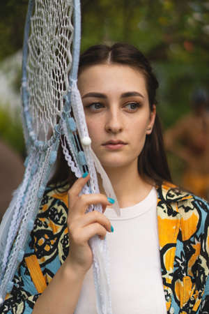 portrait of a girl holding a glass eye hanging by a thread