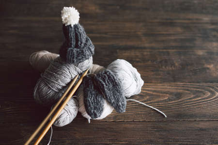 Balls of wool yarn, knitted little hat and wooden knitting needles on wooden background.の写真素材