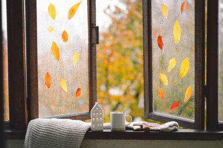 Still life details in home on a wooden window. Sweater, hot tea and autumn decor