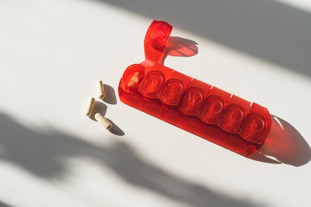 Closeup of red medical pill box with doses of tablets