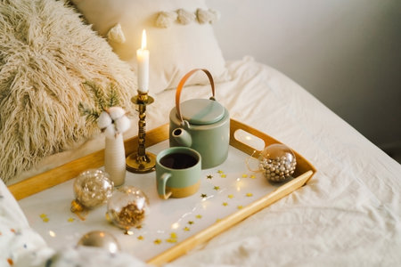 Hot tea, candle, Christmas golden balls and decorations. Christmas holiday mood in homeの写真素材