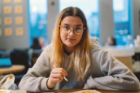 Pretty teenage girl draws a picture with poster paint.の写真素材