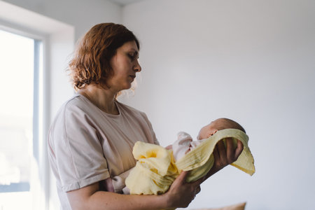 Portrait of happy mum holding infant child on hands.