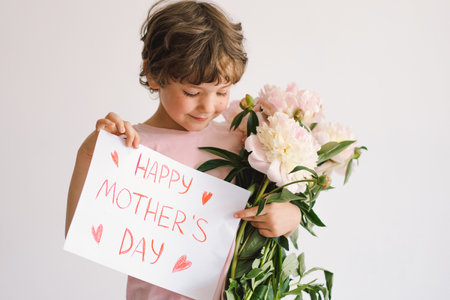 Happy Mothers Day. Cheerful happy child with Peonys bouquet.の写真素材