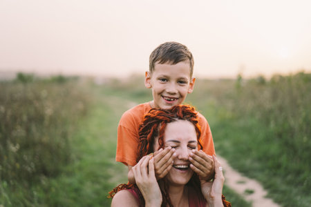 Happy mother having fun with her son outdoor. Family and love concept.の写真素材