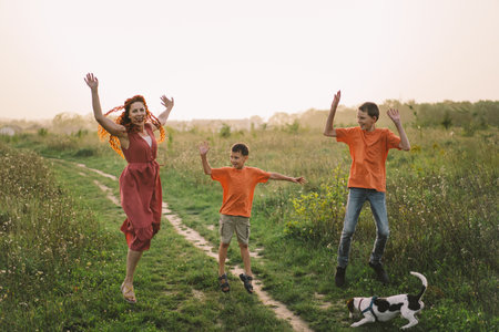 Happy mother having fun with her two sons outdoors.の写真素材