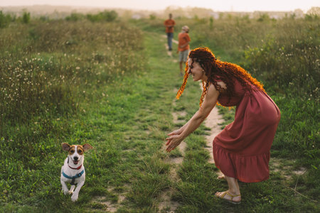 Beautiful woman plays with her Jack Russell dog in the park.の写真素材