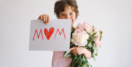 Happy Mothers Day. Cheerful happy child with Peonys bouquet.の写真素材