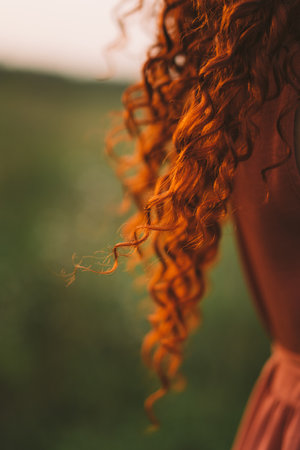 A girl with red curly hair. long hairの写真素材