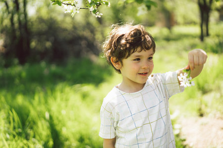 Happy little boy walking in spring garden.