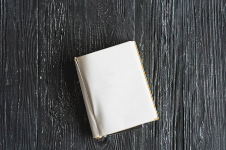 Vintage book, open, on old wooden table.の写真素材