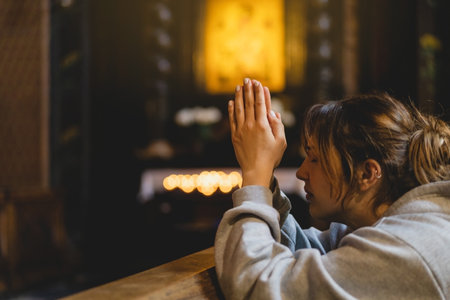 Woman praying on her knees in an ancient Catholic temple to God.の写真素材