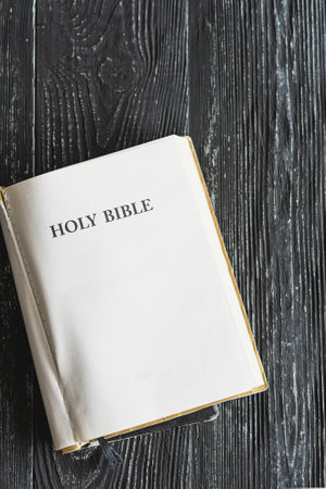 The Bible with spring flowers on a wooden background. Concept for faith