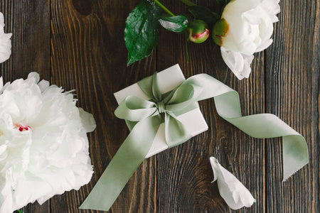 Bouquet of beautiful white peonies with gift boxes on wood backgroundの写真素材