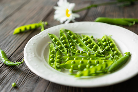 Fresh green peas on a wooden background.の写真素材