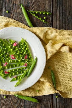 Fresh green peas on a wooden background.