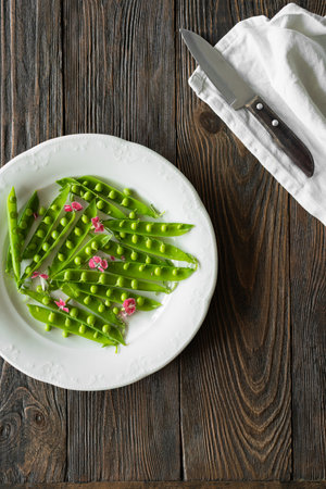 Fresh green peas on a wooden background.の写真素材