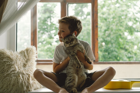 A cute boy hugs his cat. Children and pets.の写真素材