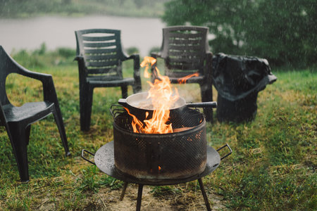 Man cooking fish on fire in nature, camping outdoors