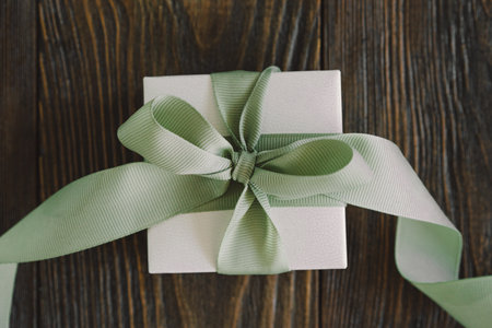 Gift or present box with green ribbon on wood backgroundの写真素材