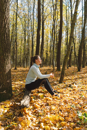 Beautiful girl listening to music and doing fitness or yoga in natureの写真素材