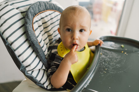 Little child with solid nutrition. Baby girl eating food and mix vegetable plateの写真素材