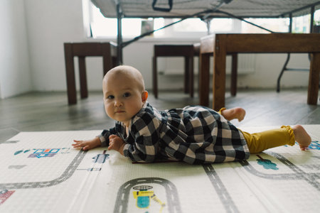 Cute baby girl playing with a toy on a play mat.の写真素材