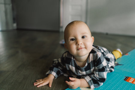 Cute baby girl playing with a toy on a play mat.の写真素材