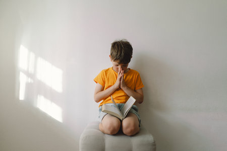 Christian boy holds bible in her hands. Reading the Holy Bible.の写真素材