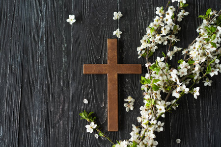 Cross with flowers on a wooden background with the inscription Christ is Risenの写真素材