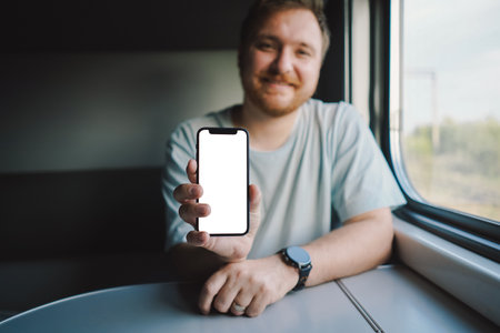 A man using a smartphone while traveling by Railway trainの写真素材
