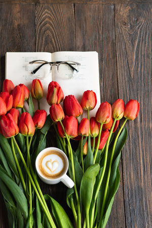 Fresh orange tulips with open book or diary on wooden backgroundの写真素材