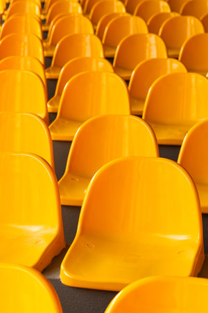 Plenty of yellow plastic seats at stadium.の写真素材