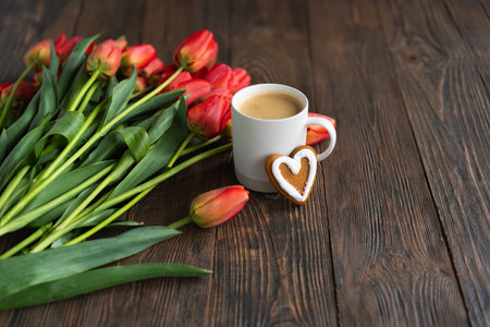 Fresh orange tulips and cappuccino mug with spring composition.の写真素材