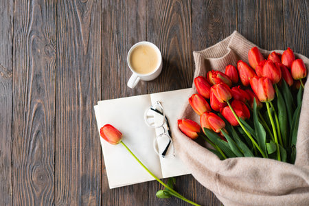 Fresh orange tulips with open book or diary on wooden backgroundの写真素材