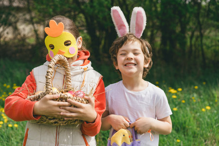 Two children hunt for Easter eggs in a spring garden. Easter traditionの写真素材