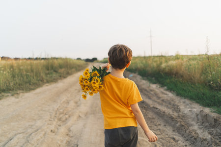 Cheerful happy child with orange flowers bouquet.の写真素材