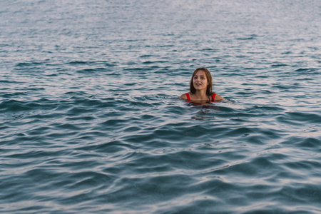 Young Woman Swimming in the Calm Ocean Waters at Dusk.